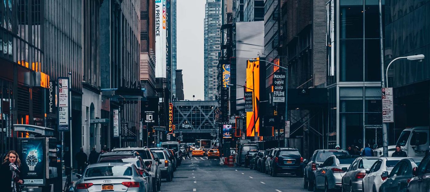 Rue commerçante en ville avec écrans et enseignes lumineuses