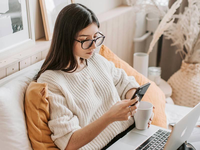 Jeune femme consultant les réseaux sociaux sur son smartphone