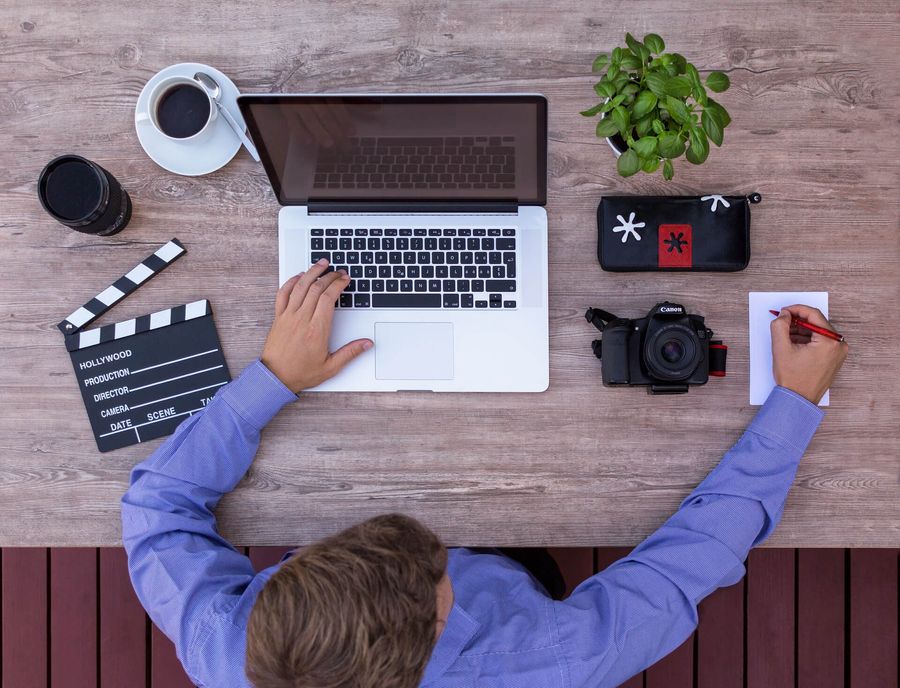 Tournage vidéo : clap de cinéma et ordinateur sur un bureau